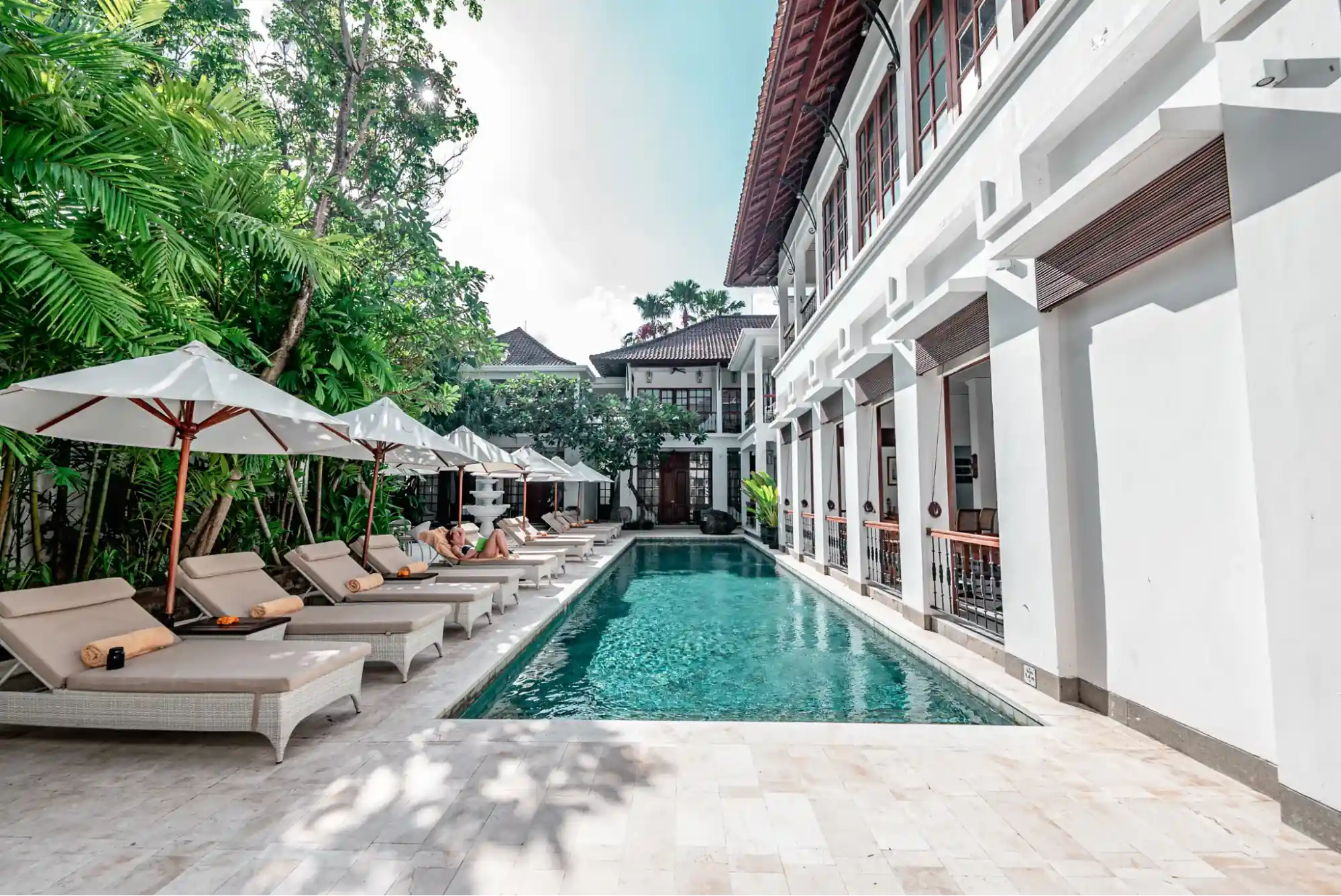 The Colony Hotel Bali, a boutique hotel in Seminyak, featuring a peaceful pool with loungers and greenery