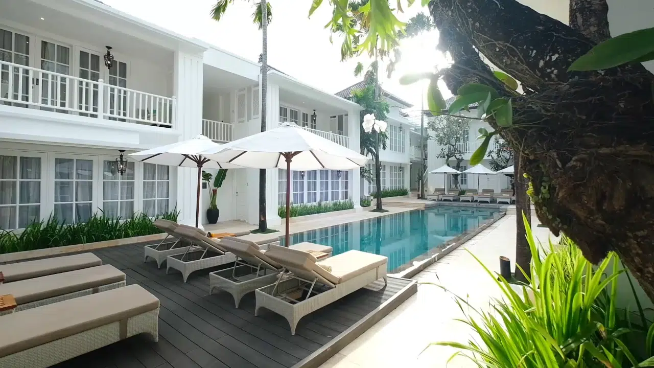 Relaxing poolside setup with sun loungers at The Colony Hotel Bali
