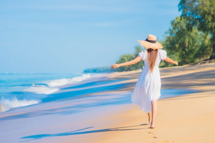 woman strolling along the golden sands of Seminyak Beach