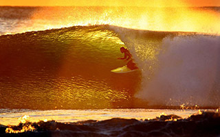 surfing in seminyal with sunset background