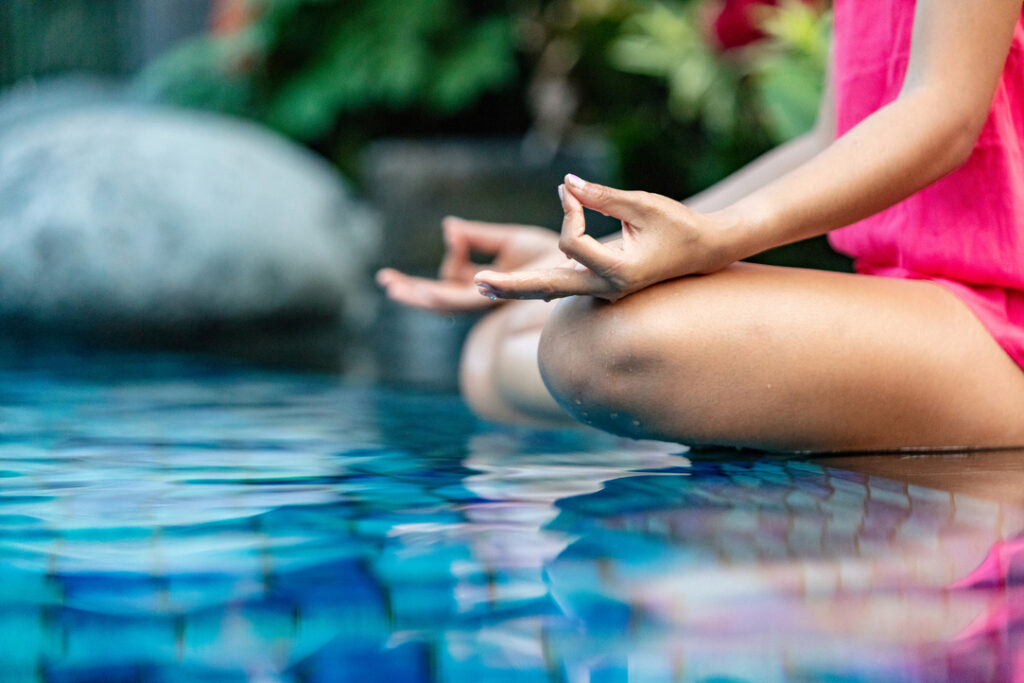 woman doing yoga on swimming pool edge