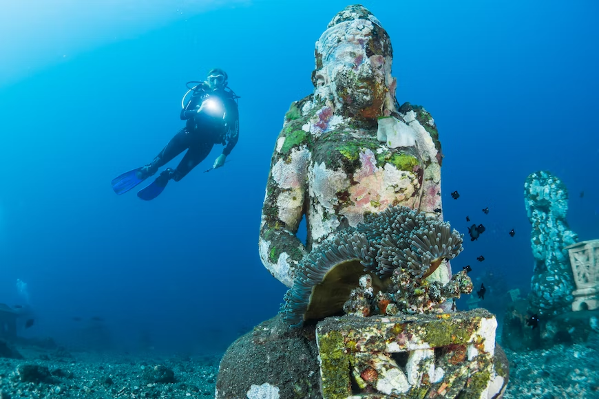 Bali scuba diving experience featuring submerged statue and marine life