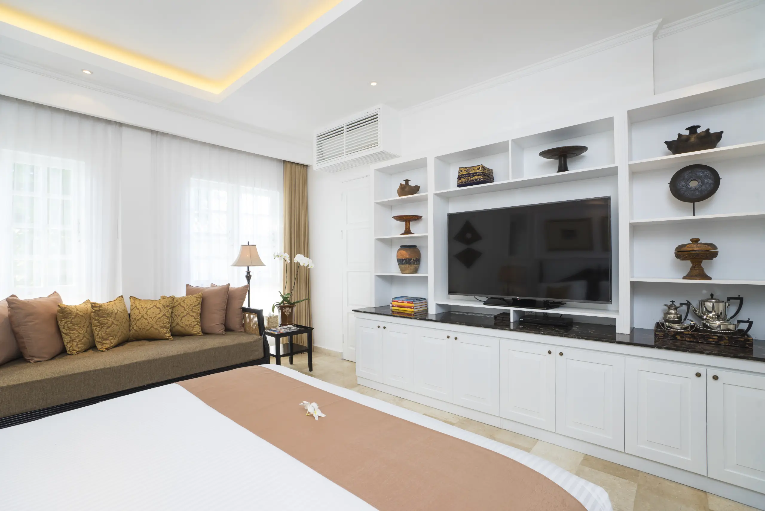 Residence Suite Room interior with bed, TV, sofa, and furniture at The Colony Hotel Bali.