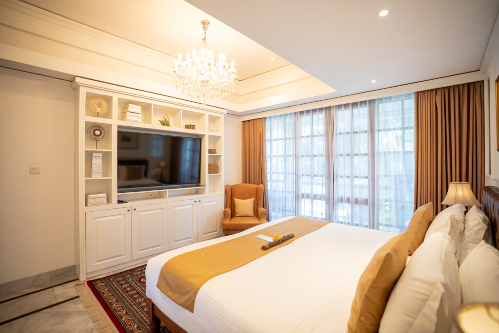Elegant hotel bedroom with white bedding and chandelier