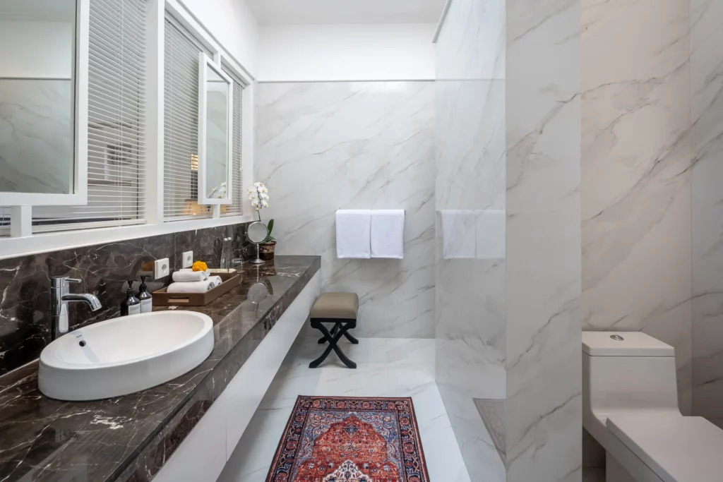 Spacious and clean bathroom with full equipment in Deluxe Room at boutique accommodation The Colony Hotel Bali, Seminyak.