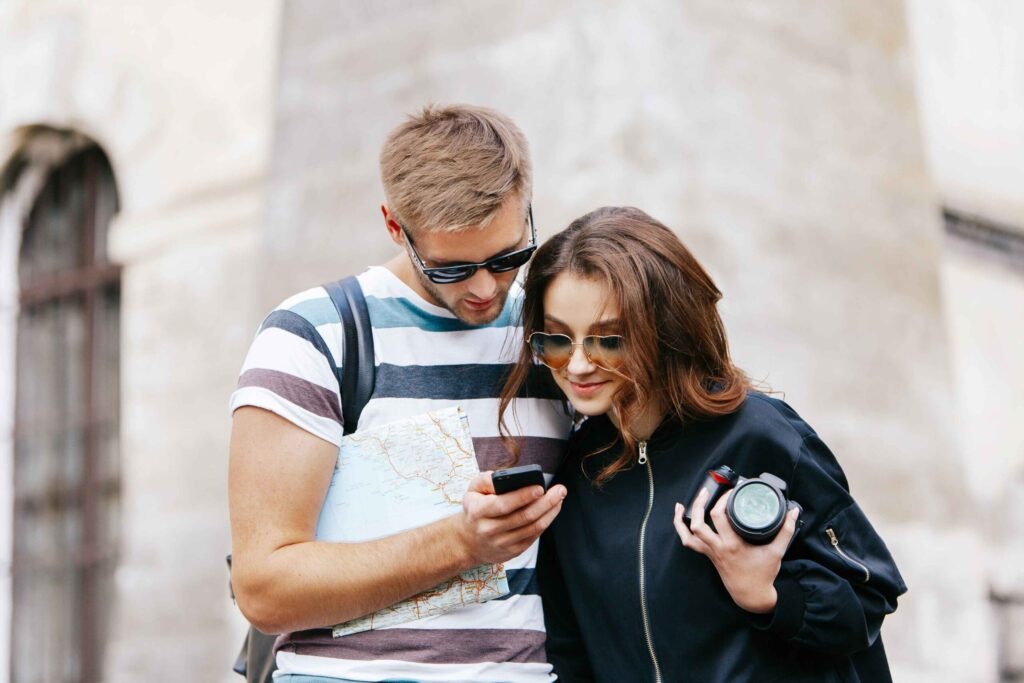 2025/05/man-woman-watch-something-phone-standing-with-touristic-map-1-scaled-1-1.jpg