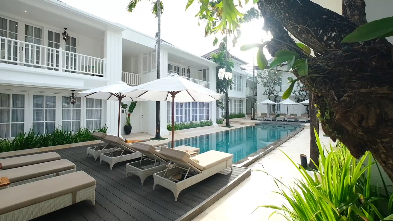 The Colony Hotel Bali pool area with sunbeds and loungers