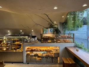 Modern bakery interior with cakes in a cooler and fresh bread on a rustic wooden stand