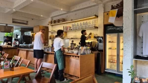 Staff serving customers at a bustling artisan bakery and coffee shop counter