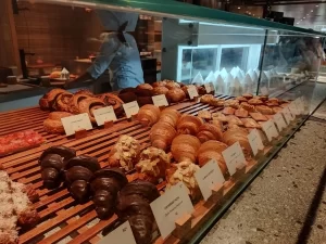 Close-up of a glass display counter full of assorted French croissants and pastries