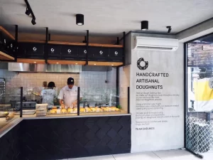 Dough Darlings artisanal doughnut shop interior with bakers at work