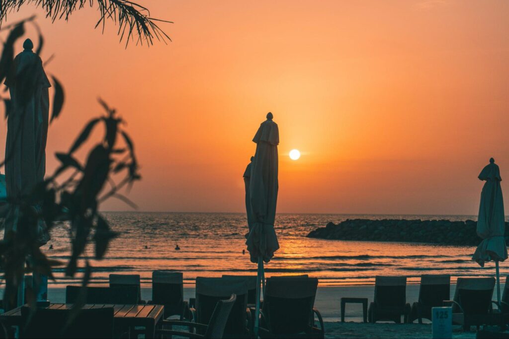 Sunset beach with ocean views, lounge chairs, and beach umbrellas