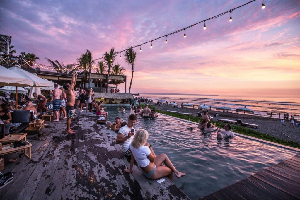 Beach club with infinity pool overlooking the ocean at sunset
